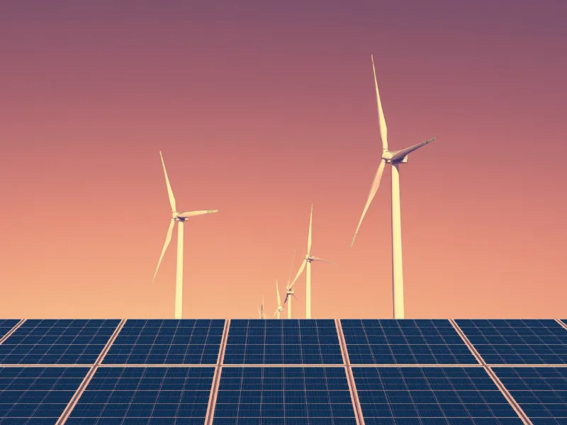 Impianto fotovoltaico con turbine eoliche sullo sfondo